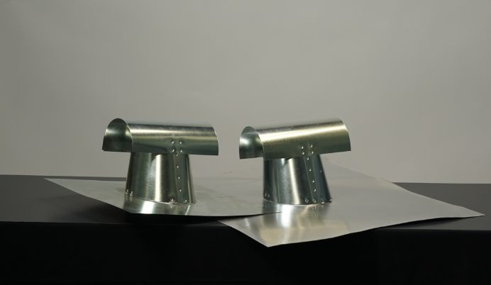 A pair of metal faucet heads sitting on top of a table.