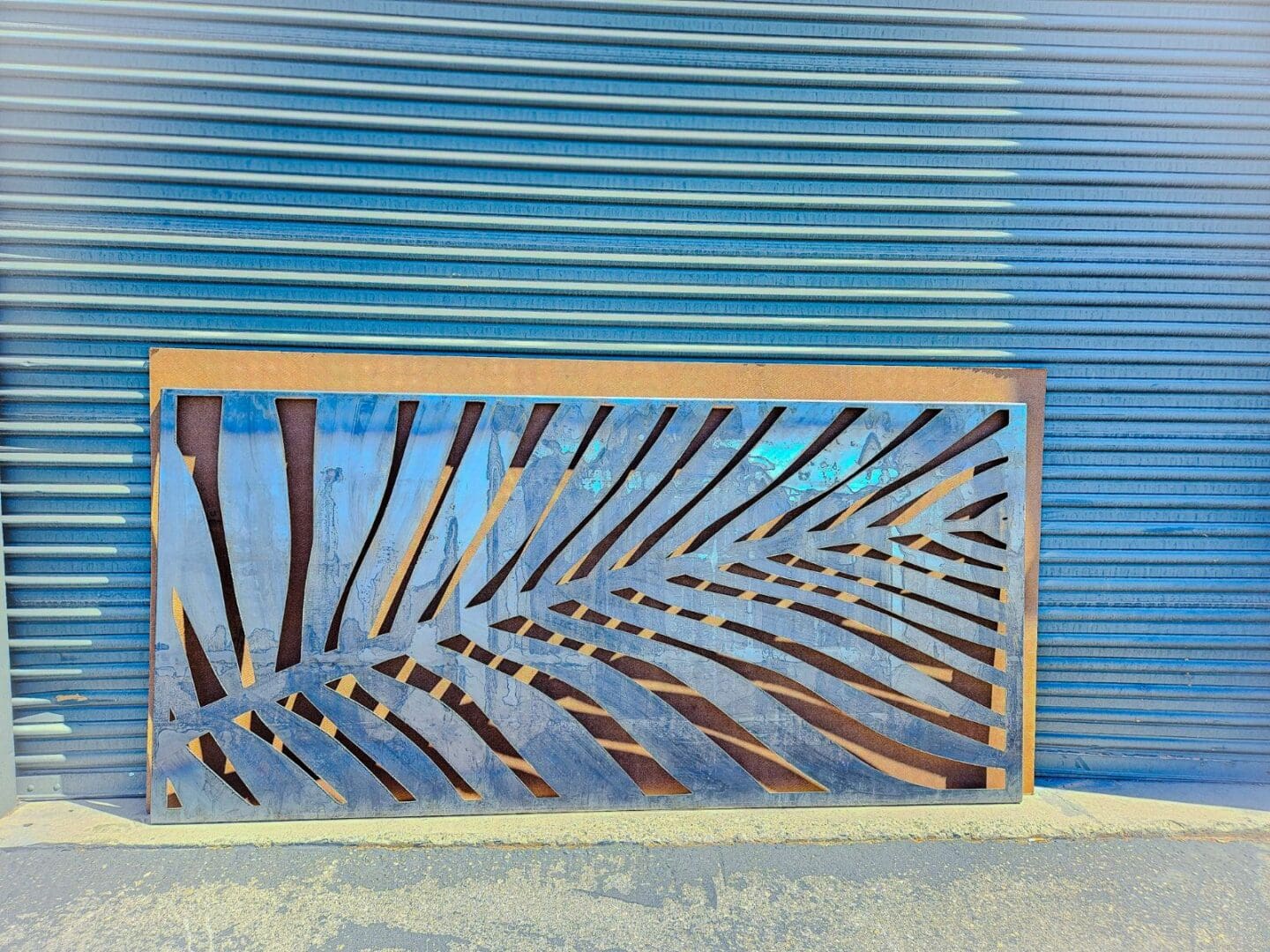 A blue wall with a wooden fence and palm leaf design.