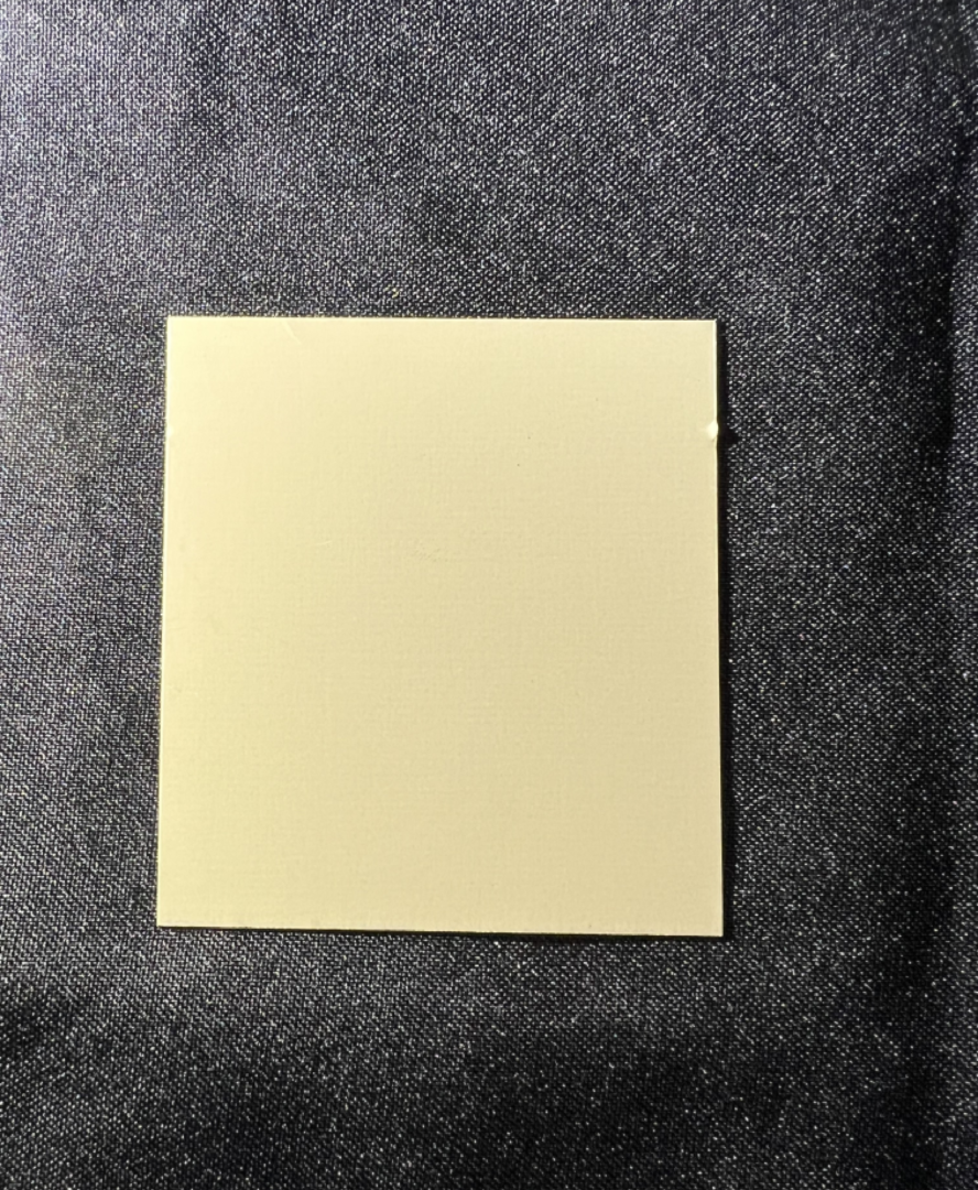 A yellow sticky note on top of a black surface.