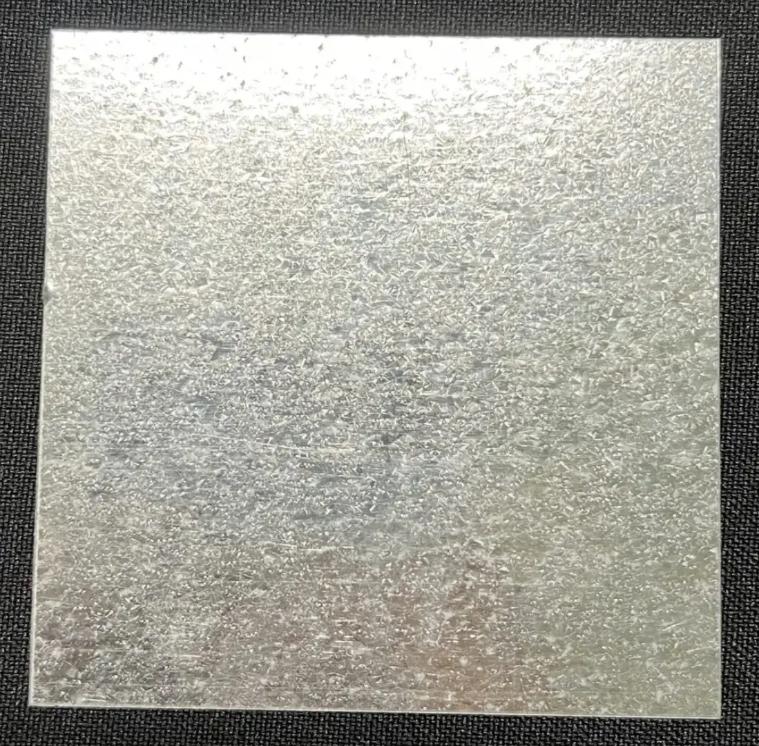 A square metal sheet with some type of pattern on it