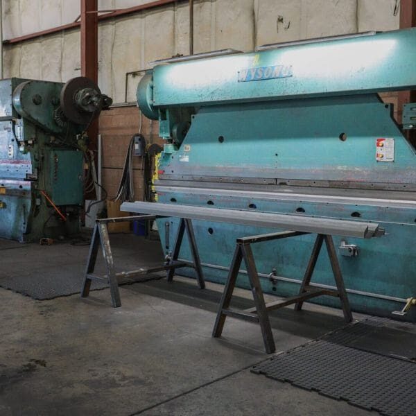 A large blue machine in a warehouse with metal work.