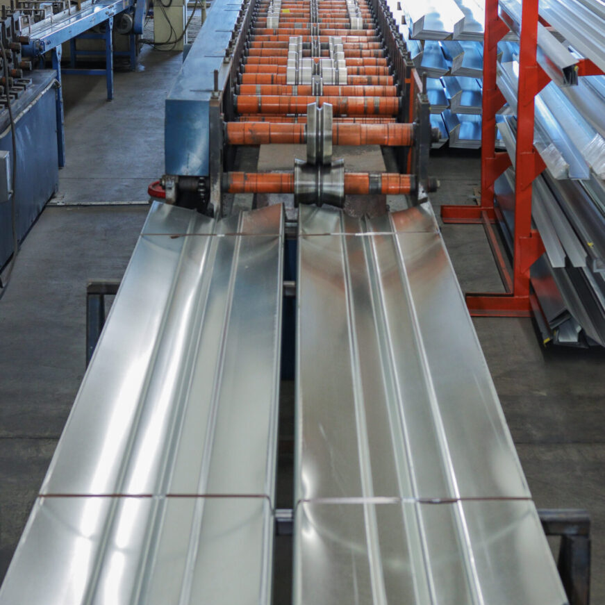 A conveyor belt with metal rails and orange wheels.